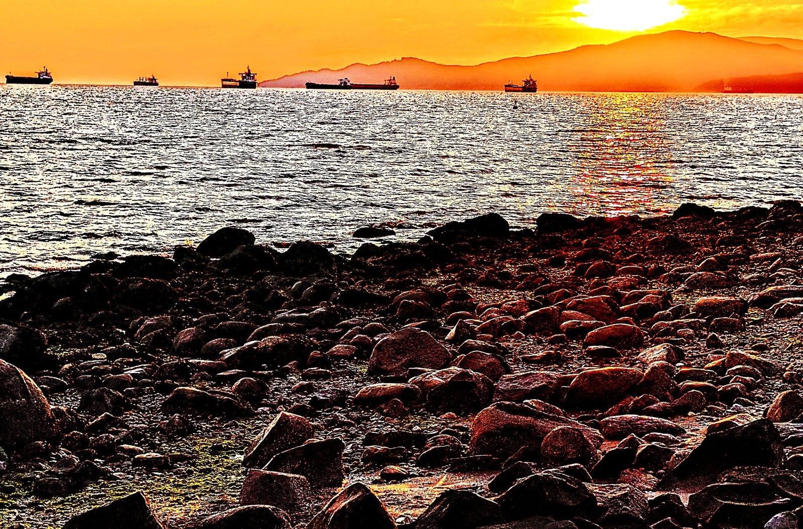 Sunset over Pacific coastal waters and a rocky shoreline